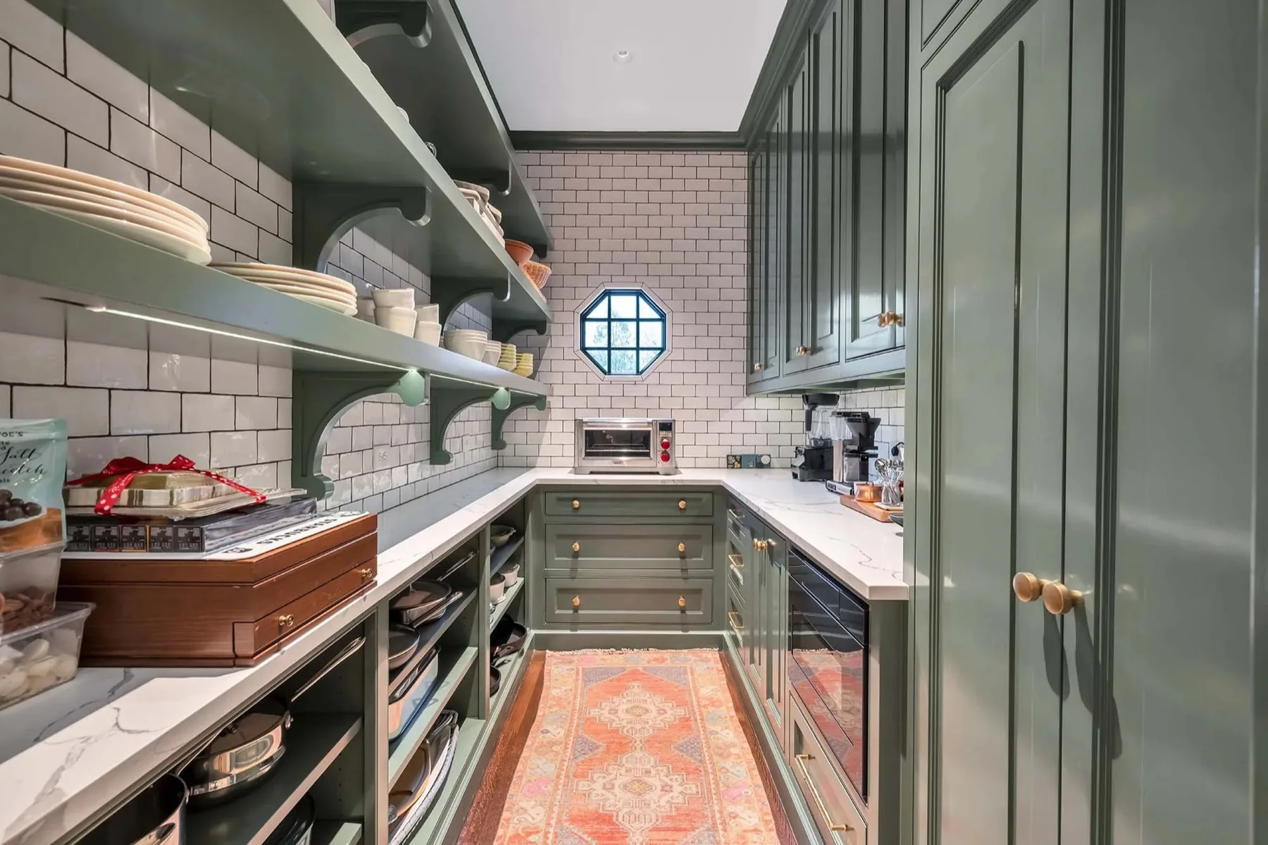 Custom painted butler pantry with open shelving, drawers, and a marble counter