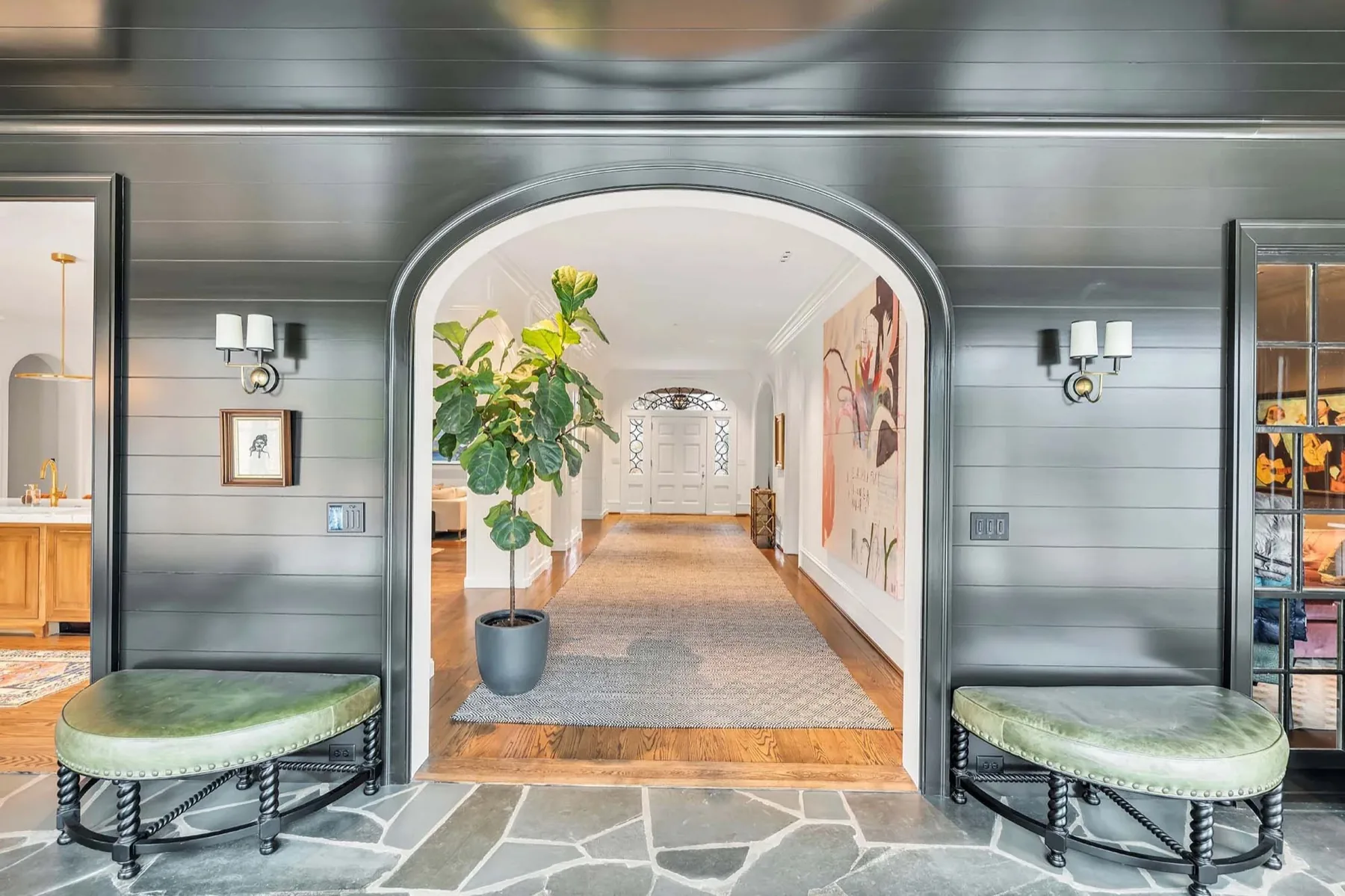 Arched millwork opening between a paneled entry and a hallway